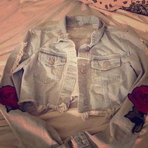 A nice blue denim Jacket, with roses on the side.